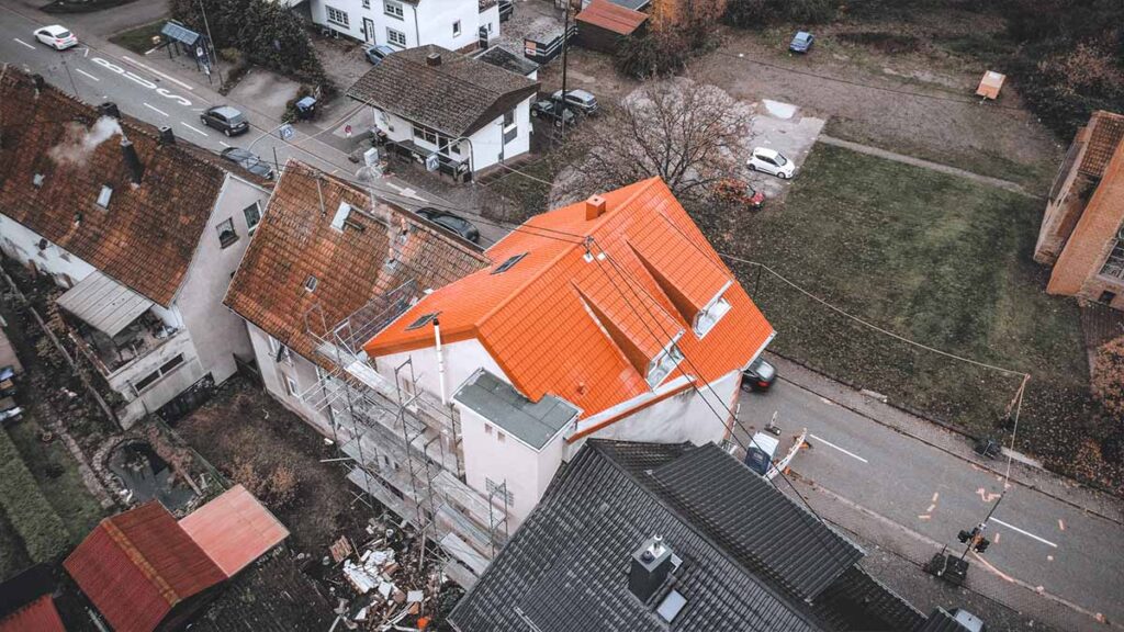 Baustelle zur Dachsanierung in Urexweiler: Eingerüstetes Gebäude mit neuer Dacheindeckung und integrierten Dachfenstern auf dem Steildach.